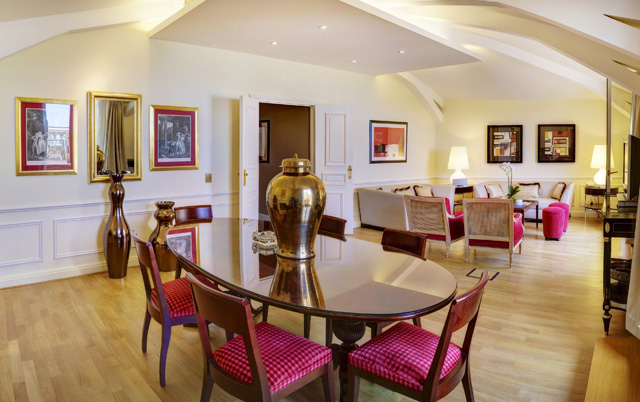 The suite boasts a dedicated dining area, complete with an opulent six-person dinner table