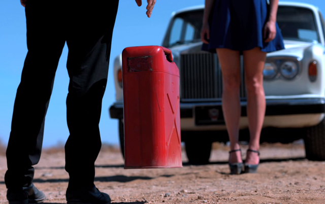 The arty shot: our mystery man drops a petrol can in front of a blonde lady